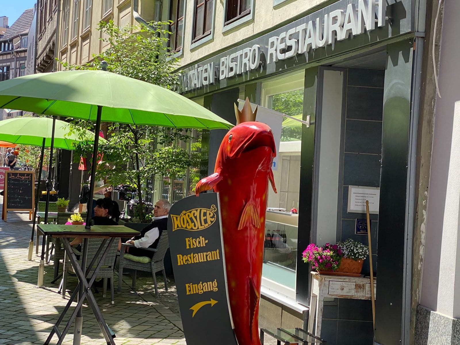 Biergarten mit grünen Sonnenschirmen vor dem Fischrestaurant Hößler